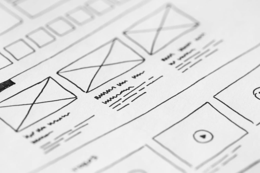 white-printer-paper-196645 Detailed close-up of a hand-drawn wireframe design on paper for a UX project.